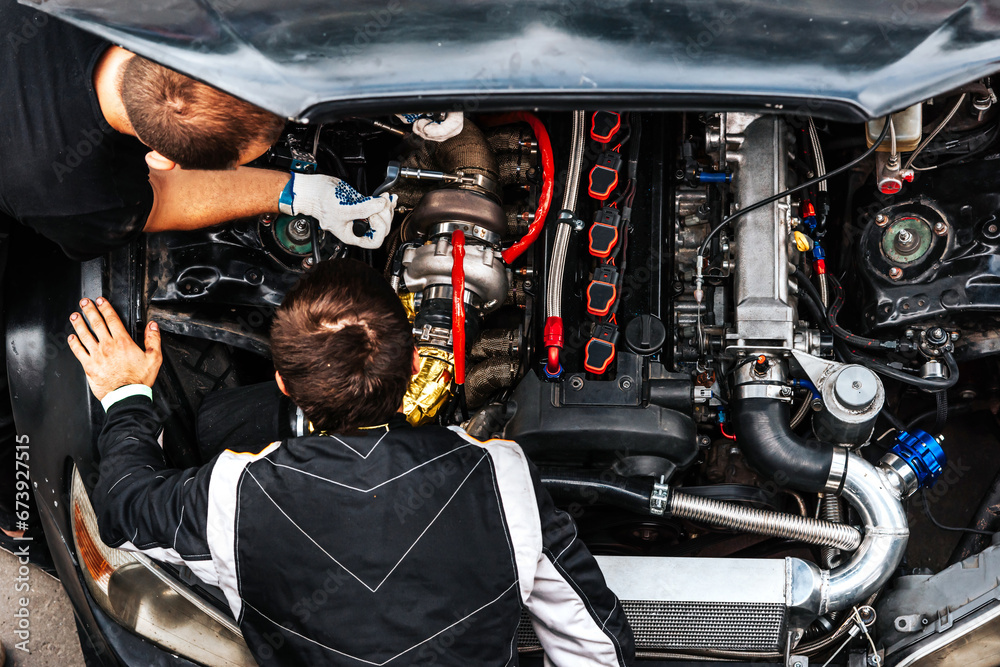 Obraz premium mechanics check the car engine before driving. under the hood. extreme sport. racing car engine problems. 