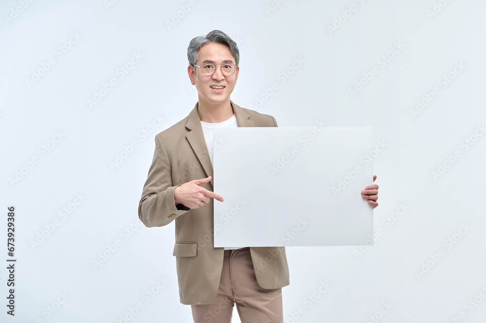 A middle-aged man in a suit and glasses is holding a white sign and making various facial expressions and gestures. A middle-aged man in a suit and glasses is holding a white sign and making various facial expressions and gestures.