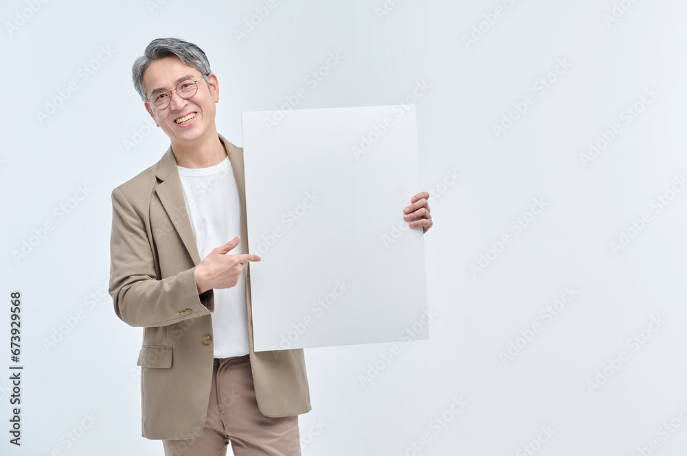 A middle-aged man in a suit and glasses is holding a white sign and making various facial expressions and gestures. A middle-aged man in a suit and glasses is holding a white sign and making various facial expressions and gestures.