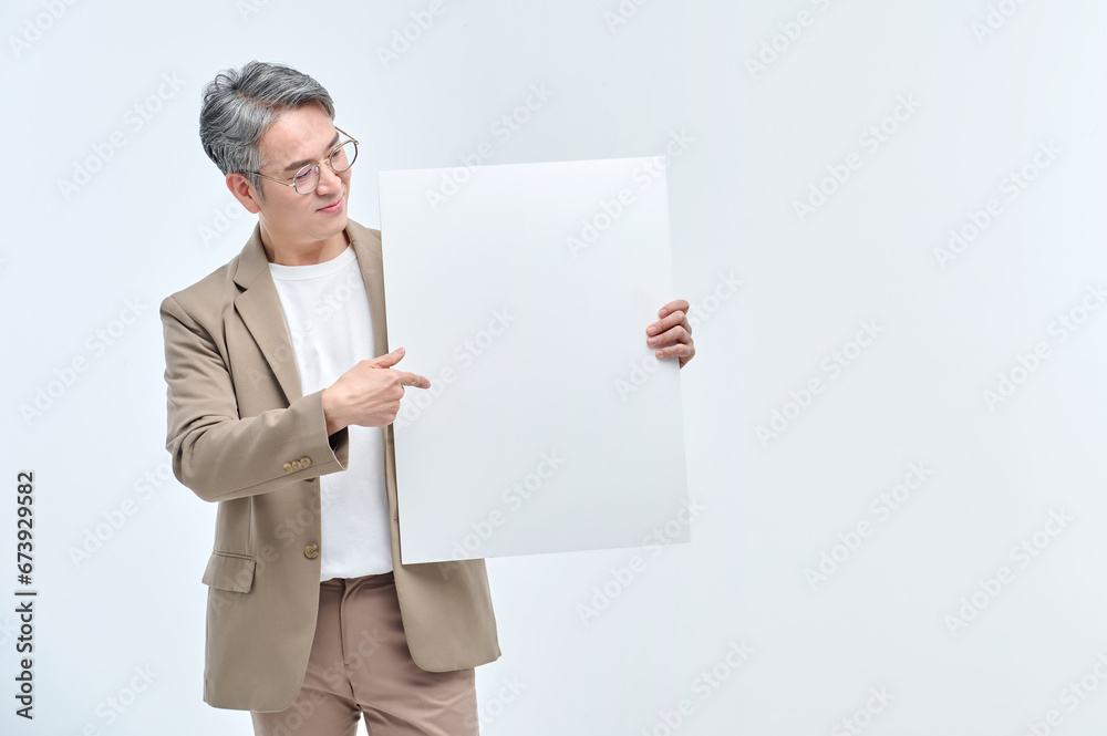 A middle-aged man in a suit and glasses is holding a white sign and making various facial expressions and gestures. A middle-aged man in a suit and glasses is holding a white sign and making various facial expressions and gestures.