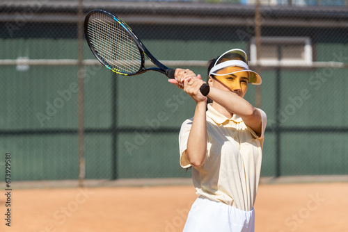 Tennis player woman playing game outdoor. Professional female sports woman hitting ball on tennis court. Ambitious sportive girl preparing for world championship competition. Strong racquet kick photo