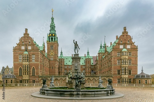 Neptune Fountain in front of Frederiksborg Castle on a cloudy day. Hillerod, Denmark.