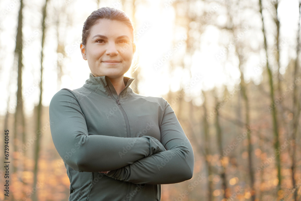 Sporty young woman enjoying the sun in winter running clothes on a cold morning in autumn outdoors Sporty young woman enjoying the sun in winter running clothes on a cold morning in autumn outdoors