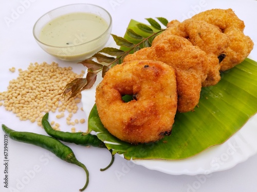 Vadai, medu vada, uzhunnu Vada, urad dal fritters, black lentils fritters with coconut chutney served on banana leaf. photo