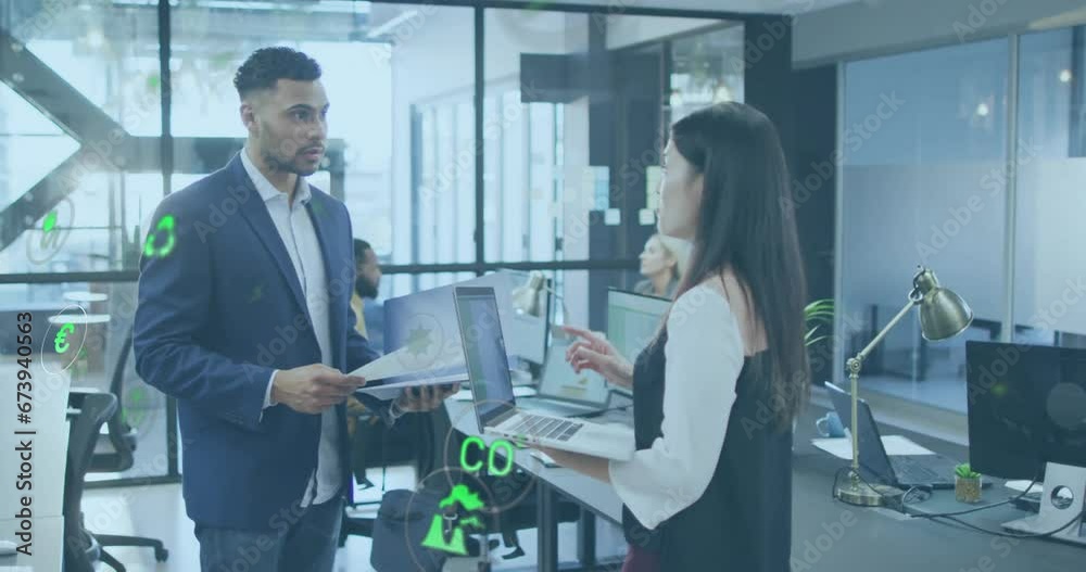 Animation of multiple icons over diverse coworkers standing and discussing reports in office