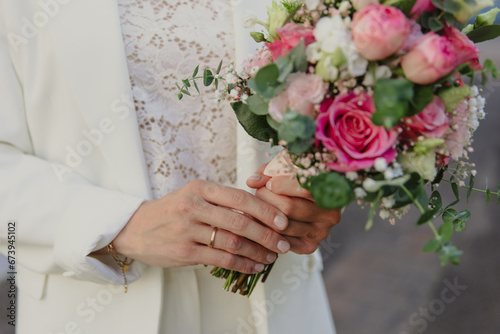 pink and white wedding bouquet in hands of the bride photo