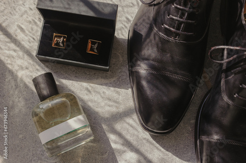 details of grooms getting ready: leather shoes, parfum and cufflinks photo