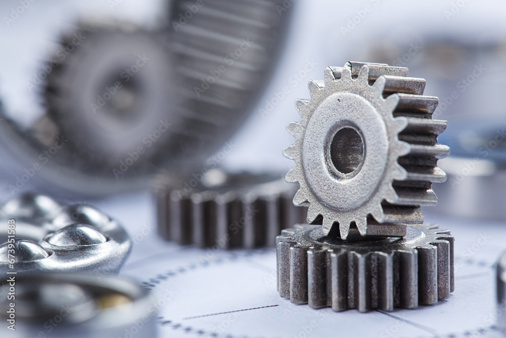 Close up metal gears and bearings. Background with drawings of the mechanism. Industrial mechanism. Close up metal gears and bearings. Background with drawings of the mechanism. Industrial mechanism.
