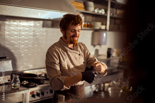 Smiling chef preparing food in professional kitchen photo