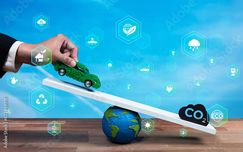 фотографія Businessman balance green EV car model scale with CO2 emission icon, demonstrate concept of ESG commitment to reduce carbon through eco friendly automobile using net zero sustainable energy
