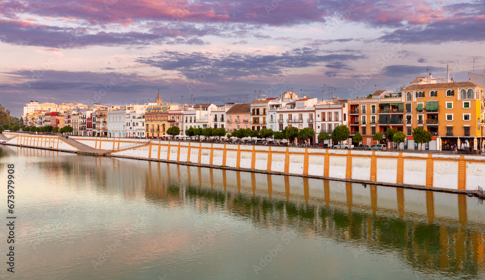 Colorful houses along the city promenade in Seville at sunset.