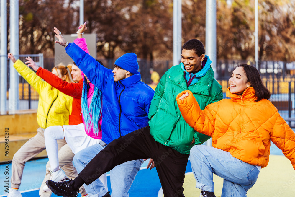 Multiracial group of young friends meeting outdoors in winter - Multiethnic students with colorful winter jackets and stylish outfits having fun in the city