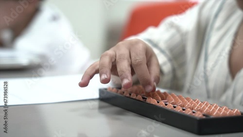 A kid is doing math showing hands and pencil, and a kid at school is doing math work on the desk using mental arithmetic and paper. 