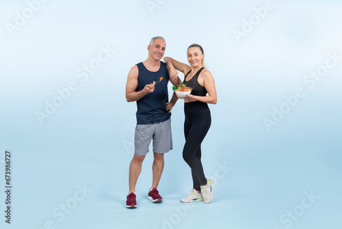 Fototapeta Naklejka Na Ścianę i Meble -  Happy smile senior man and woman portrait holding bowl of vegan fruit and vegetable on isolated background. Healthy senior couple with healthy vegetarian nutrition and body care lifestyle. Clout