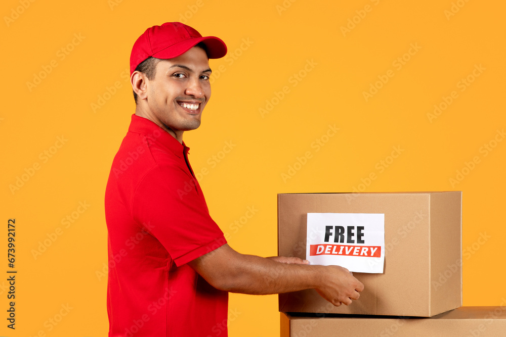courier man holds parcel box with Free Delivery label, studio courier man holds parcel box with Free Delivery label, studio