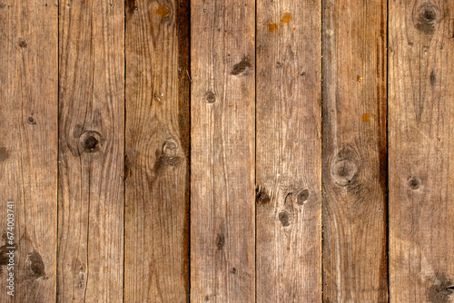 Vertical fibers of an old board close-up. Knots and fibers on an old board. The board dries out and cracks over time. Knots and mold on the weathered part of the board. 