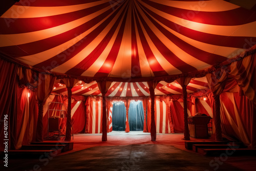 Inside interior circus tent, arena features stage and ring beneath red and white striped top, setting stage for an exciting and mesmerizing show photo