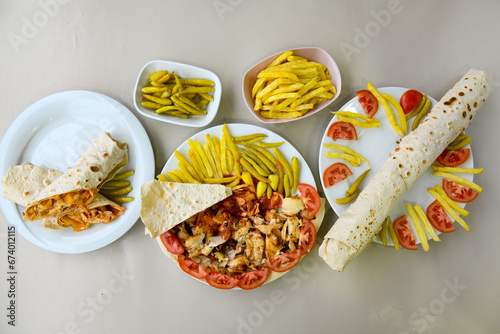 Turkish and Arabic Traditional Ramadan doner kebab with tasty tomato sauce and rice or turkish pilav in white plate on wood table background. ( Pilav ustu et doner, Hatay tavuk doner iskender kebap ) photo