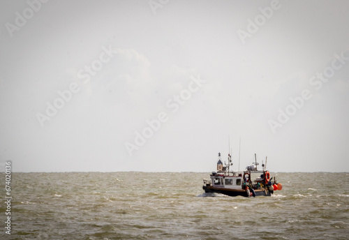 A local fishing boat returning from a day at sea, Image shows a navy blue fishing boat returning to shore on a windy day, October 2023 photo