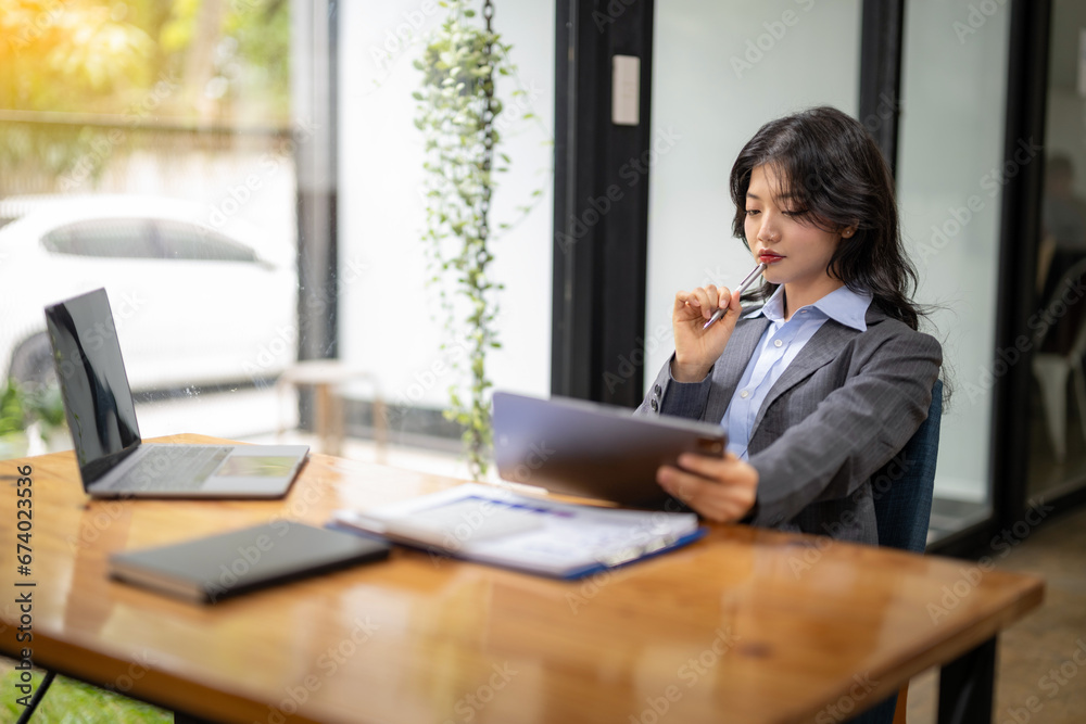 Business woman sitting and working using tablet to check news, information, marketing plan Business woman sitting and working using tablet to check news, information, marketing plan