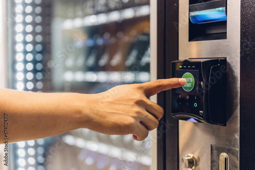 Hand man use of soft drink vending system. Man use drink coin machine at smart office or Public park. People use  Vending Machine, is robotic for the high-quality drink photo
