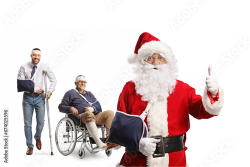 Santa claus with arm injury gesturing thumbs up in front of injured men © Ljupco Smokovski