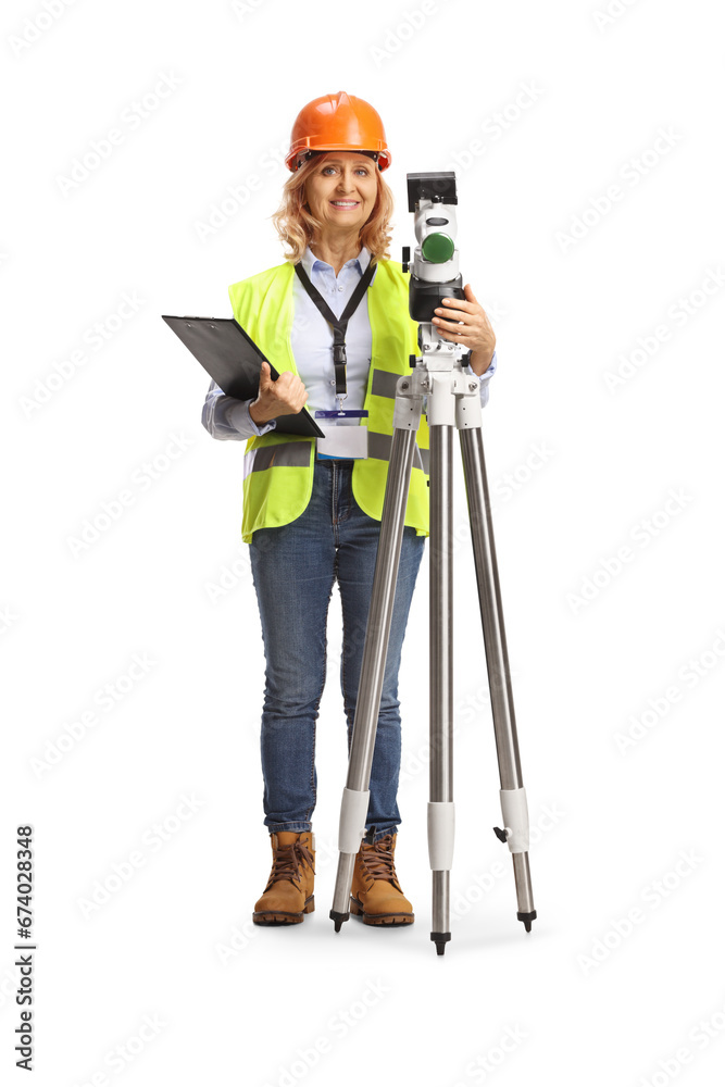 Full length portrait of a woman geodetic surveyor posing with a measuring station Full length portrait of a woman geodetic surveyor posing with a measuring station