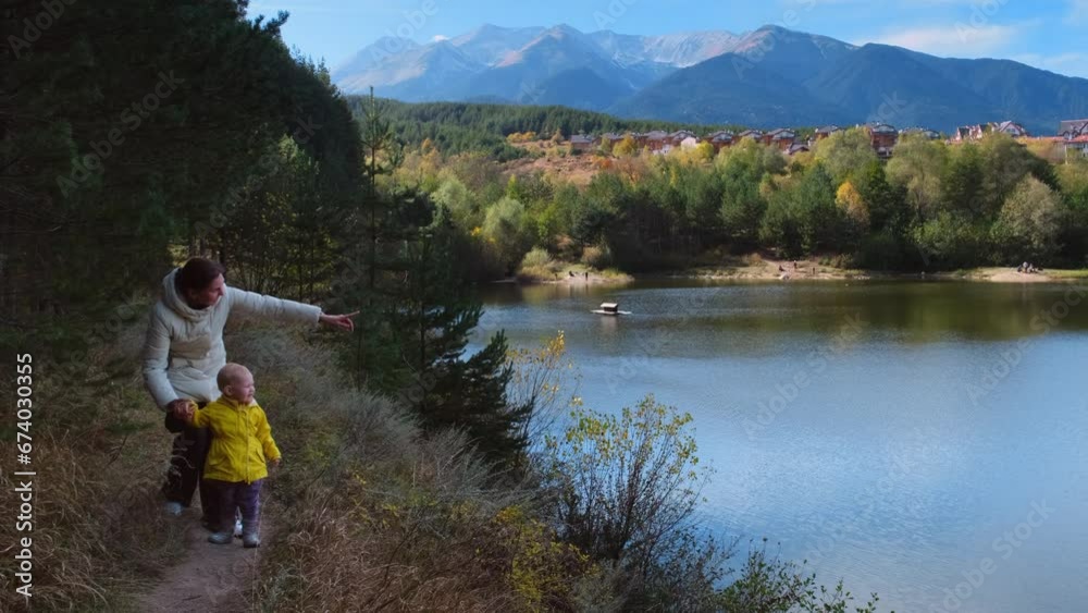mother and daughter walk in nature and admire the scenery.autumn nature and good weather. beautiful mountains and mountain lake in Bulgaria. High quality 4k footage mother and daughter walk in nature and admire the scenery.autumn nature and good weather. beautiful mountains and mountain lake in Bulgaria. High quality 4k footage