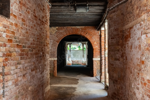 Old, empty arched hall or passage made of bricks with wooden beams in Venice, Italy
