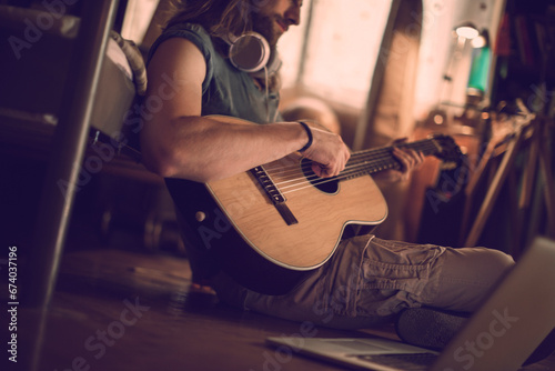 Bearded man playing guitar at home photo