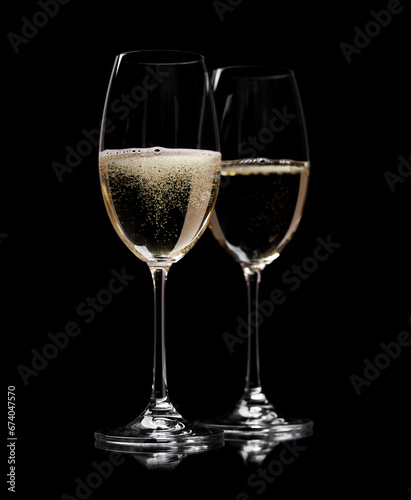 Two champagne glasses on a black