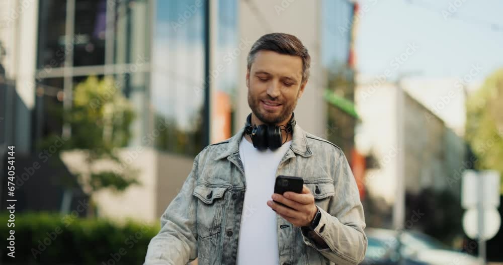 Man with grey hair walking in the street while using smartphone, typing. Man with grey hair walking in the street while using smartphone, typing.
