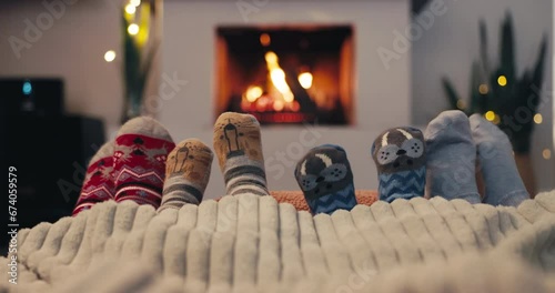 Christmas, socks and family by the fireplace on a sofa in the living room in their home together. Love, children and parents feet closeup while bonding in the December festive season for celebration