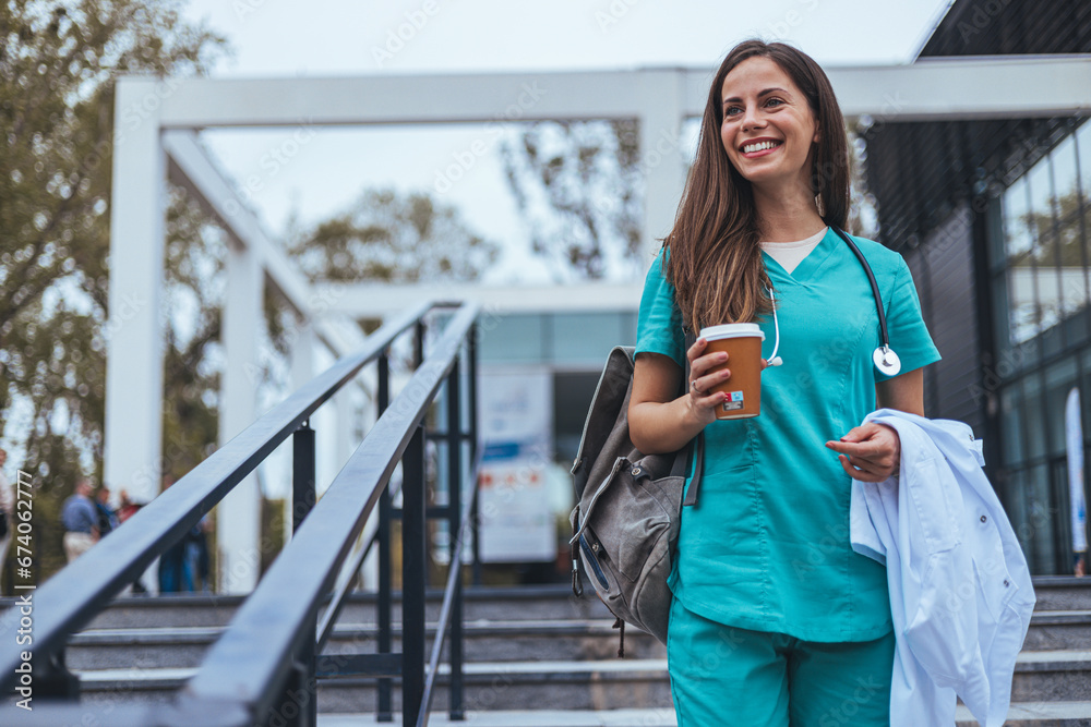 Hardworking mid adult beautiful nurse climbs the stairs to her apartment after a hard day at work. Portrait of happy young female nurse. A female healthcare worker leaving the house in her uniform. Hardworking mid adult beautiful nurse climbs the stairs to her apartment after a hard day at work. Portrait of happy young female nurse. A female healthcare worker leaving the house in her uniform.