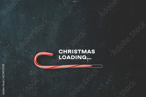 Christmas loading inscription on a black background and candy photo