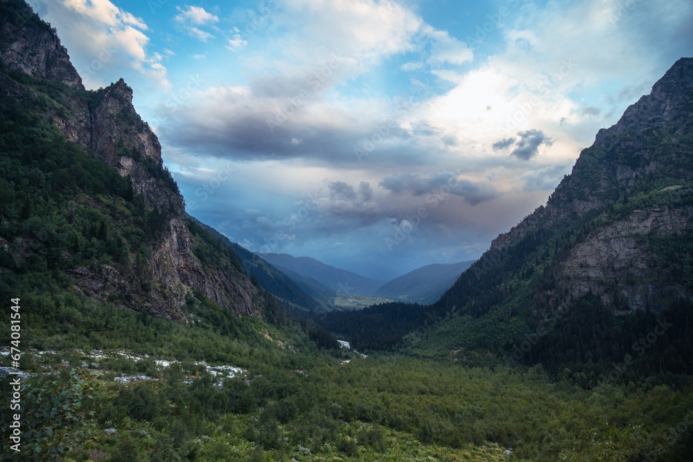 Distant view, valley among high Caucasian mountains, summer evening, dramatic rain clouds. way to Shdugra waterfall, Mazeri, Svaneti, Georgia