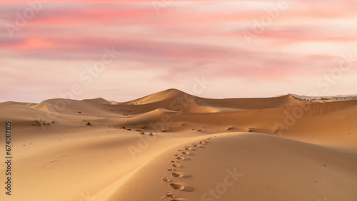Trail of camel footprint on sand dunes of Sahara Desert in northern Africa, a vast expanse of sand and dunes that stretches as far as the eye can see.