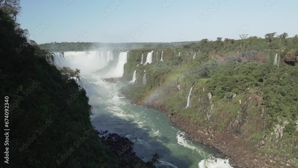 The Iguazu Falls are located at the border between Brazil and Argentina and are one of the seven wonders of the world, a populat ravel destination in the rainforest of south America. The Iguazu Falls are located at the border between Brazil and Argentina and are one of the seven wonders of the world, a populat ravel destination in the rainforest of south America.