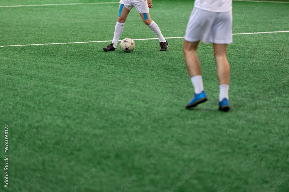 Five-a-side soccer players playing game in indoor stadium on artificial turf. Five-a-side soccer players playing game in indoor stadium on artificial turf.