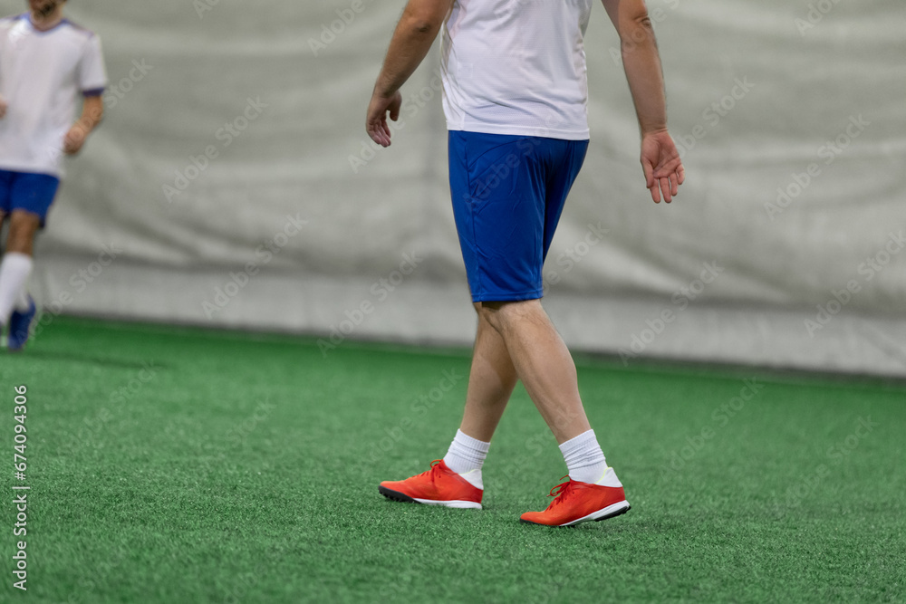 Futsal five-a-side players on artificial grass field indoor. Futsal five-a-side players on artificial grass field indoor.