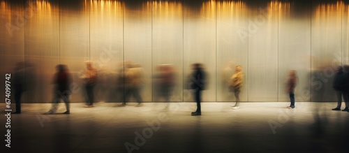 People hurry about their business against the backdrop of a city concrete wall. Long exposure. Motion blur. Abstract background. © Restyler