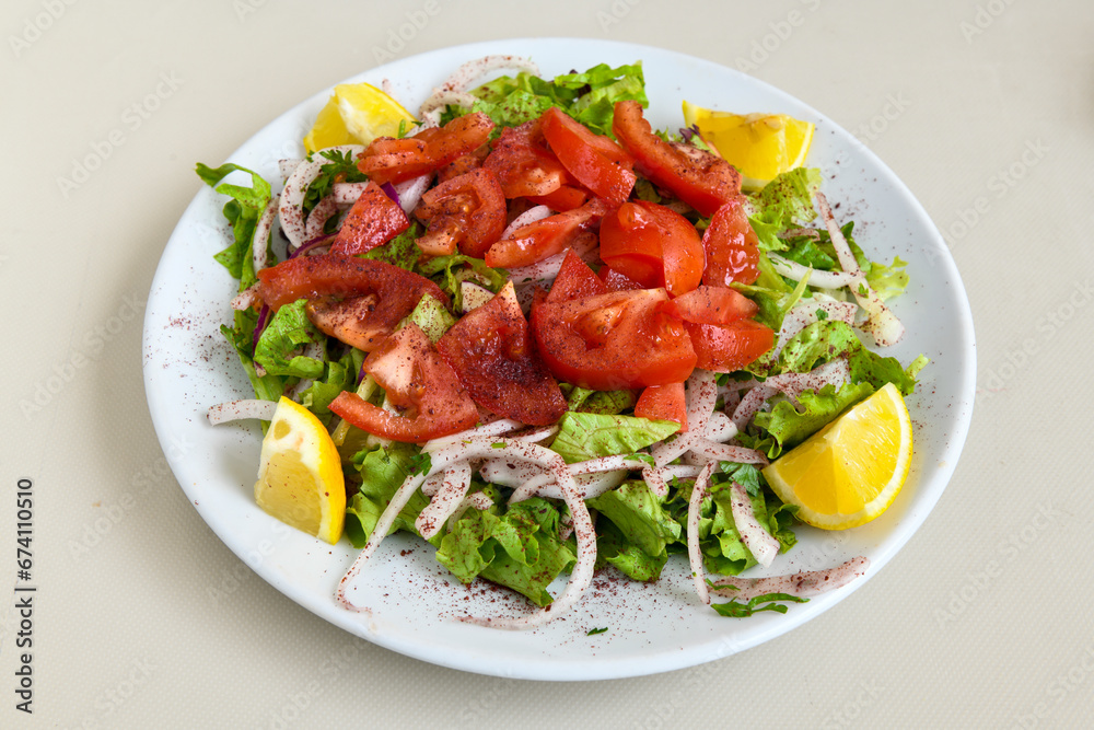 Green salad with arugula, lamb and tomatoes. Healthy vegan dish. Top view at table. Turkish Coban (choban) salata or Shepherds salad, Akdeniz salad in white bowl. Green salad with arugula, lamb and tomatoes. Healthy vegan dish. Top view at table. Turkish Coban (choban) salata or Shepherds salad, Akdeniz salad in white bowl.