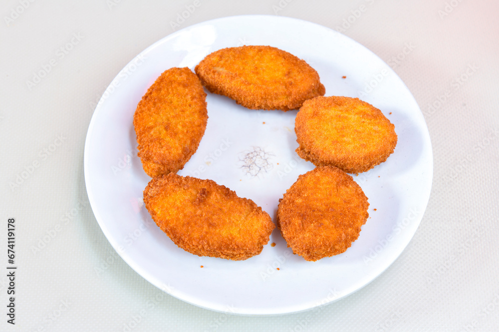 Fried Chicken breast hot crispy strips crunchy chicken tenders isolated on white background.Nuggets isolated on white background on a plate Fried Chicken breast hot crispy strips crunchy chicken tenders isolated on white background.Nuggets isolated on white background on a plate