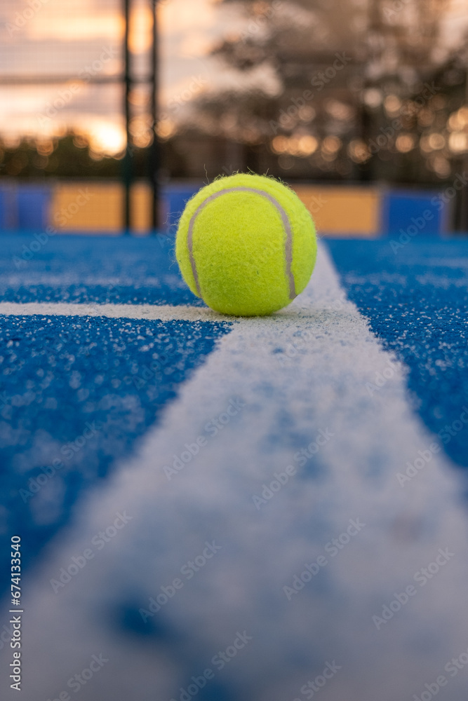 blue paddletennis court and one ball on the line, selective focus
