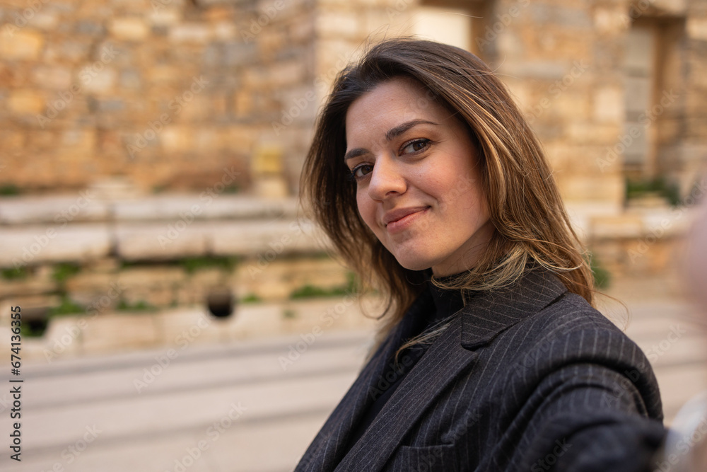 Young tourist woman takes selfie with ephesus historical site. Young tourist woman takes selfie with ephesus historical site.