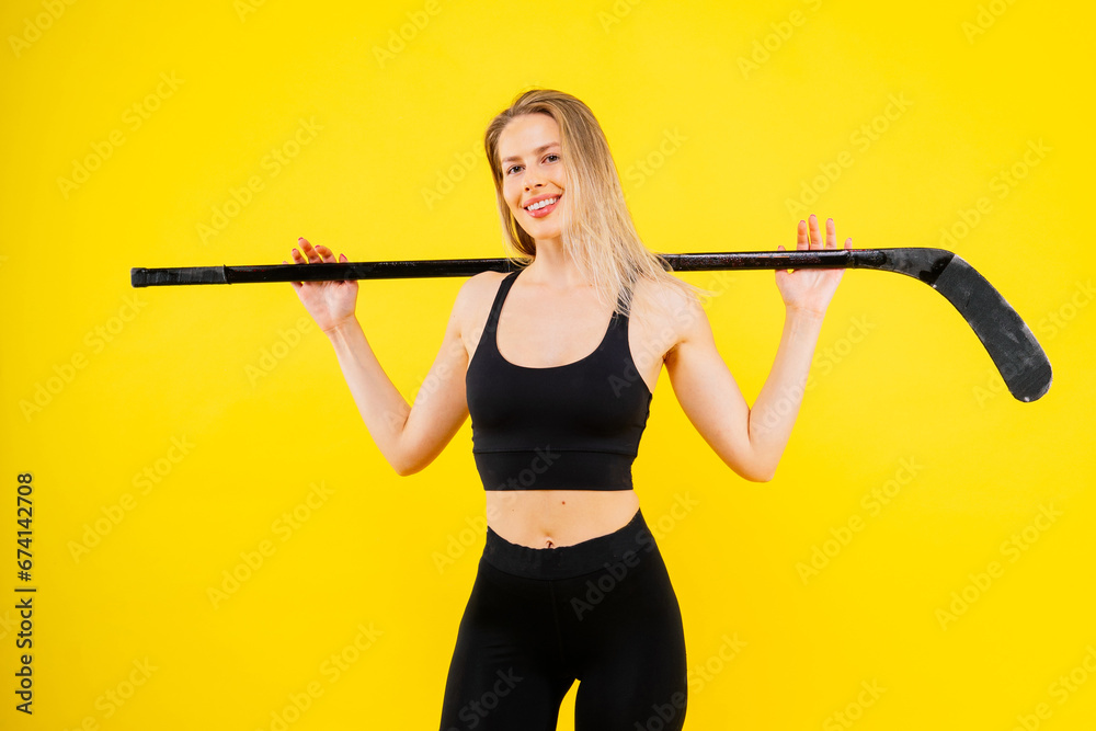 Ice hockey fan female in sports wear with hockey stick in studio Ice hockey fan female in sports wear with hockey stick in studio