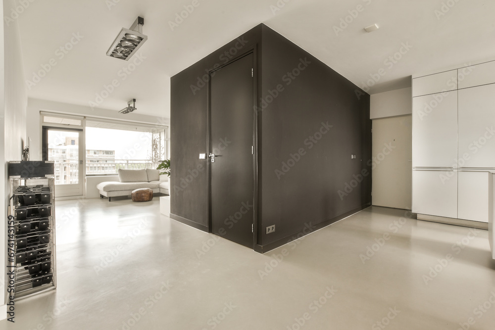 Obraz premium a kitchen and living room in a modern style apartment with an open door leading to the bedroom area, as well as it is