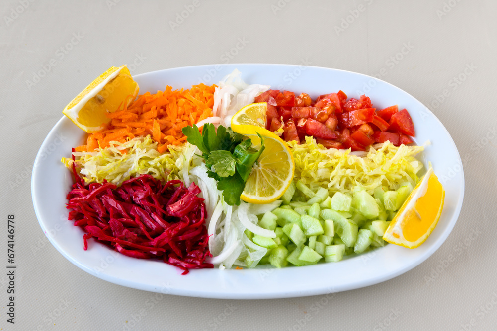 Green salad with arugula, lamb and tomatoes. Healthy vegan dish. Top view at table. Turkish Coban (choban) salata or Shepherds salad, Akdeniz salad in white bowl. Green salad with arugula, lamb and tomatoes. Healthy vegan dish. Top view at table. Turkish Coban (choban) salata or Shepherds salad, Akdeniz salad in white bowl.