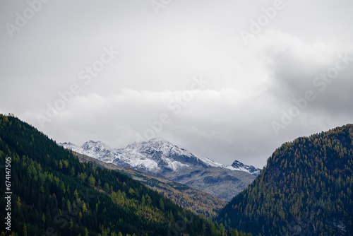 landscape with clouds over snowcapped peaks in the alps in autumn photo