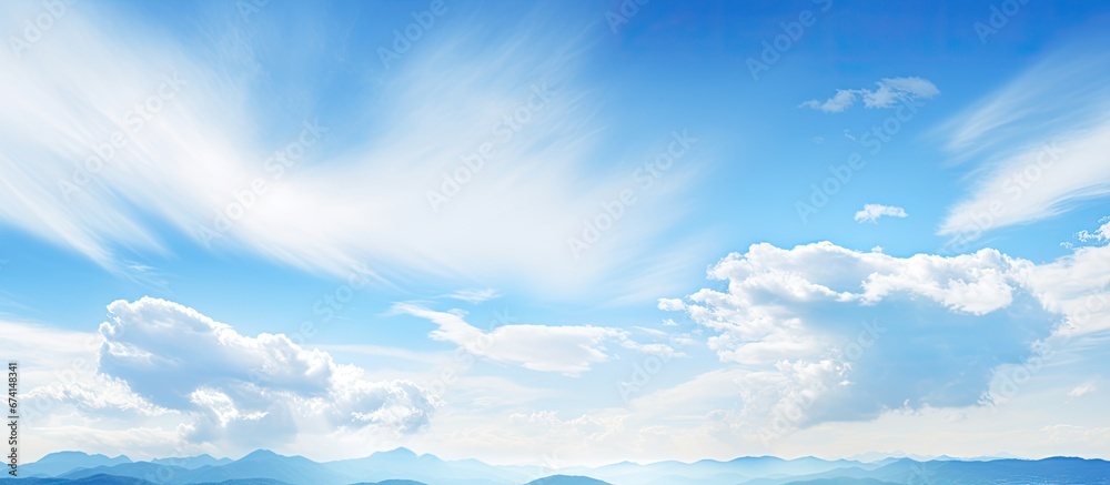 A pleasant day with sunshine where clouds dot the sky against the backdrop of a towering mountain A pleasant day with sunshine where clouds dot the sky against the backdrop of a towering mountain